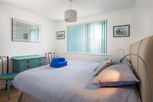 een slaapkamer met een bed, een bureau en een raam bij Fairwinds,Bigbury on sea ,Three-bed Beach House in Bigbury on Sea