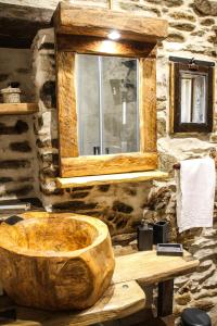 uma banheira de madeira numa casa de banho em pedra com uma janela em il Bosco em Roccaforte Mondovì