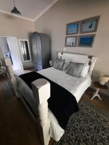 um quarto com uma cama grande e um cobertor preto e branco em Nel's Cottage, a private and peaceful cottage em Benoni