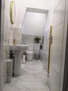 biała łazienka z umywalką i toaletą w obiekcie Sweeney Stays, Cadzow Apartment w mieście Hamilton