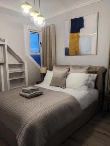 sypialnia z dużym łóżkiem z białą pościelą w obiekcie Sweeney Stays, Cadzow Apartment w mieście Hamilton