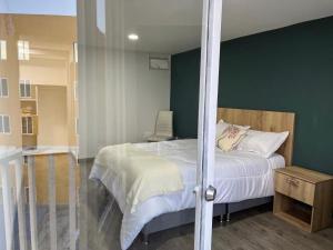 een slaapkamer met een bed en een groene muur bij Apartamentos céntricos y cómodos en Chapinero in Bogota