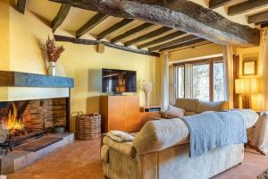 sala de estar con sofá y chimenea en Villa privada de lujo Can Riera, en Pujals dels Cavallers