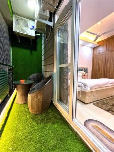 una habitación con paredes verdes y una habitación con ventana en Airport Bliss Apartment+Balcony & Netflix + Prime, en Jaipur