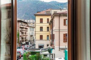 Elle offre une vue sur une rue de la ville depuis sa fenêtre. dans l'établissement Grand Maison, à Côme