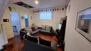 uma sala de estar com um sofá e uma televisão de ecrã plano em Hospedagem Camisa 10 em Santos