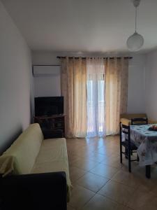 - un salon avec un canapé et une table dans l'établissement Olisa Apartment, à Vlorë