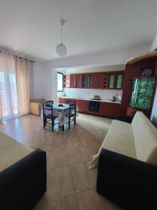 Il comprend un salon avec une table et une cuisine. dans l'établissement Olisa Apartment, à Vlorë