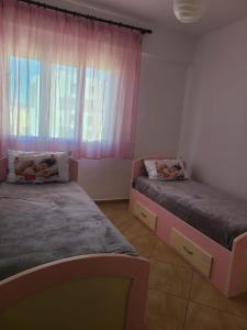 - une chambre avec 2 lits et une fenêtre dans l'établissement Olisa Apartment, à Vlorë