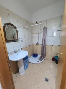 La salle de bains est pourvue d'un lavabo et de toilettes. dans l'établissement Olisa Apartment, à Vlorë
