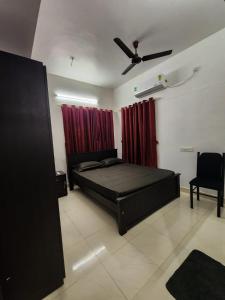 - une chambre avec un lit et un ventilateur de plafond dans l'établissement Urban Haven Short Stays, à Trivandrum
