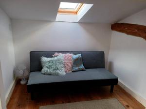 a blue couch with pillows sitting in a room at Fleur Du Soleil in Agudelle
