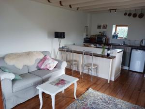 a living room with a couch and a kitchen at Fleur Du Soleil in Agudelle