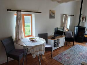 a living room with a table and chairs and a television at Fleur Du Soleil in Agudelle