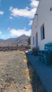 a white building with a bench next to it at La Finca de Los Padres in Tefía