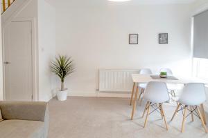 een witte woonkamer met een tafel en stoelen bij BIG Monthly DIS, Central, Modern, 2bed APT, Sleeps up to 5 in Swindon