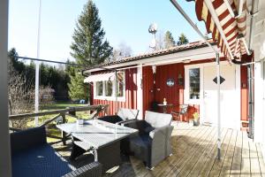 a patio with a table and chairs on a deck at Cozy cottage with 10 beds near Landvetter in Landvetter