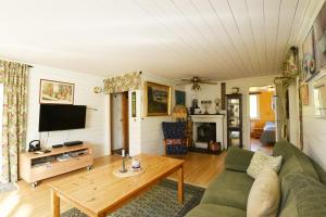 Cozy cottage with 10 beds near Landvetter في Landvetter: غرفة معيشة مع أريكة وتلفزيون