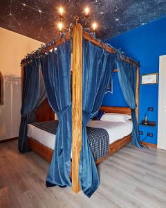 a bedroom with a canopy bed with blue walls at Binario Magic RistoHotel in Palazzago