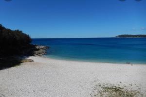 a sandy beach with the ocean and blue water at Leda in Pula