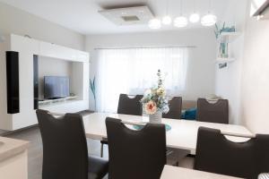 jadalnia ze stołem i krzesłami oraz telewizorem w obiekcie Türkiz apartman w mieście Kőszeg