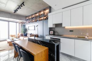 a kitchen with white cabinets and a wooden table at Chic and Scenic Studio Flat in Sisli in Istanbul