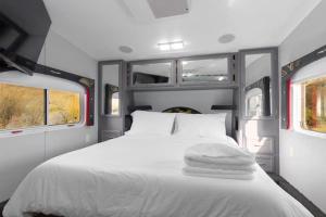 a white bed in an rv with two windows at Harley Davidson Ranch Glampling With Kids Play Zone in Ramona