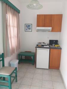 a kitchen with a white refrigerator and a table at Panoramic View in Agios Prokopios