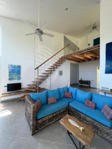 Villa Azul في بوكاتشيكا: غرفة معيشة مع أريكة زرقاء ودرج