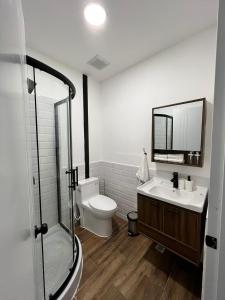 y baño con aseo, lavabo y espejo. en Suites By SalcedO en Santo Domingo