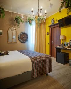 - une chambre avec un grand lit et des murs jaunes dans l'établissement Binario Magic RistoHotel, à Palazzago