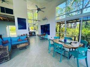 Villa Azul في بوكاتشيكا: غرفة معيشة مع طاولة وكراسي ونوافذ
