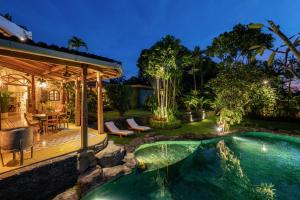 a backyard with a swimming pool and a house at Casa Mila - 4BR Luxury Villa 5 Min from Canggu Beach in Canggu