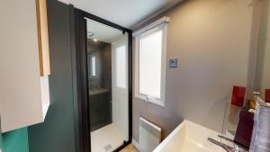 La salle de bains est pourvue d'un lavabo et d'une fenêtre. dans l'établissement Camping Officiel Siblu La Réserve, à Gastes