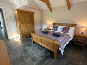 a bedroom with a large bed with two night stands at Beudy Howel - A beautiful converted barn close to the coast in Llansadurnen