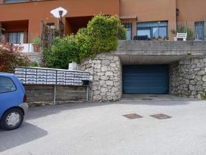 une voiture garée devant un immeuble avec garage dans l'établissement L'angolo di pace e relax del lago di Garda, à Riva del Garda