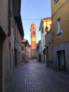 維梅卡特的住宿－Casa di Arianna in centro storico a Vimercate，一条空的街道,远处有钟楼