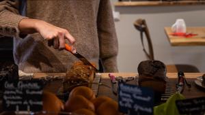a person holding a knife on a table with fruit at Hôtel Vauban in Le Palais