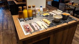 a buffet with meats and cheese and bottles of juice at Hôtel Vauban in Le Palais