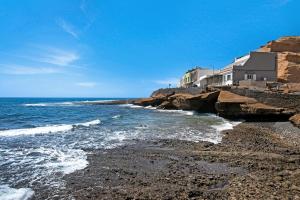 uma vista para o oceano a partir de uma praia rochosa em Las Arenas Medio em La Mareta