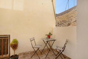 une terrasse avec deux chaises et une table avec une plante dans l'établissement Las Arenas Medio, à La Mareta