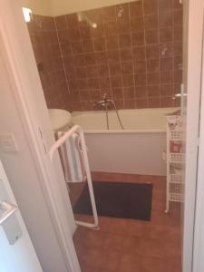 une salle de bain avec une baignoire et une chaise dedans dans l'établissement Mer et Soleil, à Saint-Raphaël