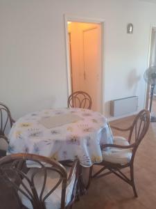 Zimmer mit einem Tisch, Stühlen, einem Tisch und einer Tür in der Unterkunft Mer et Soleil in Saint-Raphaël
