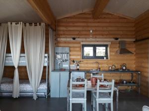 a kitchen with a table and chairs in a cabin at Mountain Log Cabin O Garrano in Cabeceiras de Basto