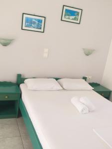 a bedroom with a bed with two green night stands at Panoramic View in Agios Prokopios