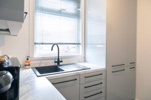 eine Küche mit einem Waschbecken und einem Fenster in der Unterkunft BIG Monthly DIS, Central, Modern, 2bed APT, Sleeps up to 5 in Swindon