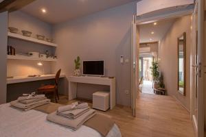 a bedroom with a bed and a desk and a television at Heraclea Residential Apartments in Hvar