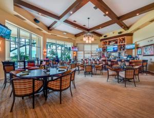 un restaurant avec des tables et des chaises et un bar dans l'établissement Lely Greenlinks Top Floor - on Golf Course, Minutes from Beaches, Downtown!, à Naples