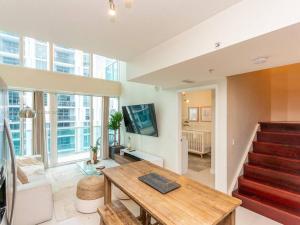 a living room with a wooden table and a staircase at Beautiful Brickell Loft with Free Parking in Miami