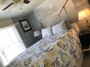 a bedroom with a bed with a comforter and a window at Highland Park Pittsburgh in Pittsburgh